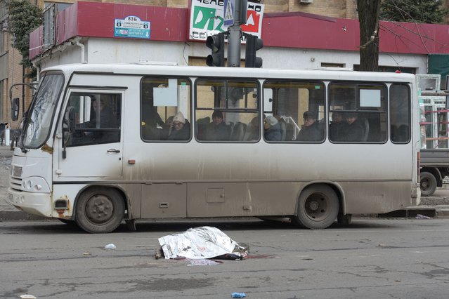 The body of a woman killed in recent shelling lies on a street in Donetsk, Russian-controlled Ukraine, on February 20, 2024, amid the Russia-Ukraine conflict. (Photo by AFP Photo/Stringer)