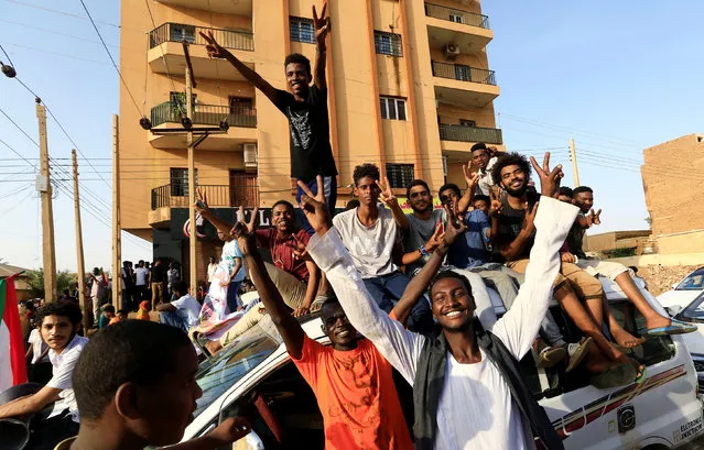 Sudanese people chant slogans as they celebrate, after Sudan's ruling military council and a coalition of opposition and protest groups reached an agreement to share power during a transition period leading to elections, along the streets of Khartoum, Sudan, July 5, 2019. (Photo by Mohamed Nureldin Abdallah/Reuters)