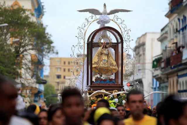 People participate as the statue of Our Lady of Charity, the patron saint of Cuba, is carried during a procession in Old Havana, Cuba, September 8, 2016. (Photo by Enrique De La Osa/Reuters)