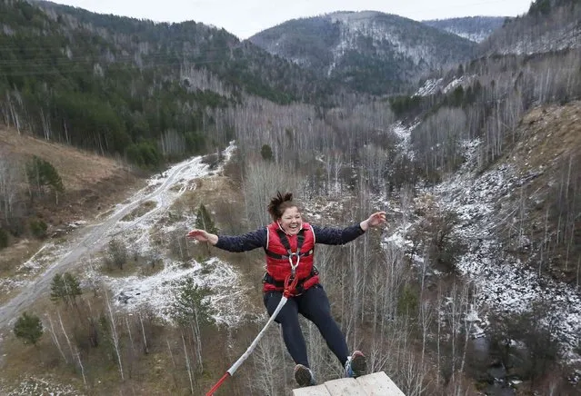 A member of the amateur rope-jumping group “Exit Point” jumps from a 44-metre high (144-ft) waterpipe bridge in the Siberian Taiga area outside Krasnoyarsk, November 2, 2014. (Photo by Ilya Naymushin/Reuters)