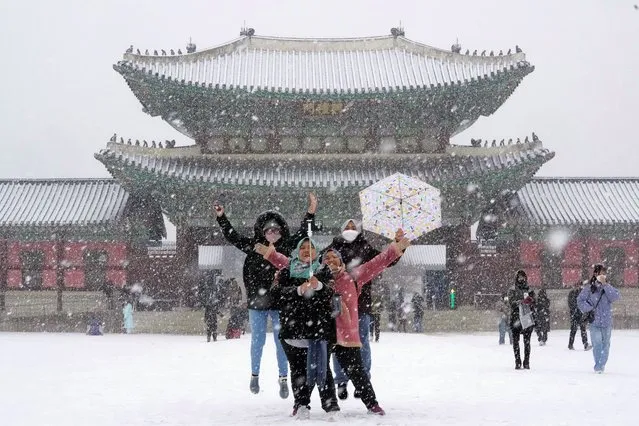 Visitors take a selfie in the snow at the Gyeongbok Palace, the main royal palace during the Joseon Dynasty, and one of South Korea's well known landmarks in Seoul, South Korea. Thursday, December 15, 2022. (Photo by Ahn Young-joon/AP Photo)