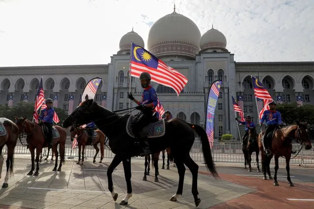 Horse riders holding Malaysian flag take part in a rehearsal for the Independence Day event, in Putrajaya, Malaysia on August 28, 2020. (Photo by Lim Huey Teng/Reuters)