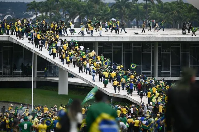 Bolsonaro supporters storm the National Congress in Brasilia, Brazil, 08 January 2023. Hundreds of supporters of former Brazilian President Jair Bolsonaro invaded the headquarters of the National Congress, and also Supreme Court and the Planalto Palace, seat of the Presidency of the Republic, in a demonstration calling for a military intervention to overthrow President Luiz Inacio Lula da Silva. The crowd broke through the cordons of security forces and forced their way to the roof of the buildings of the Chamber of Deputies and the Senate, and some entered inside the legislative headquarters. (Photo by Andre Borges/EPA/EFE/Rex Features/Shutterstock)
