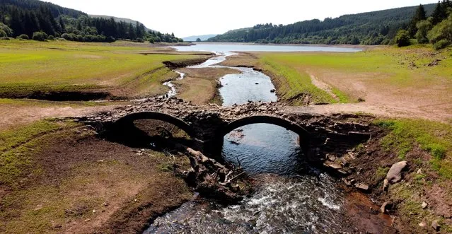 A view of a bridge, which is usually submerged, over the dried bed of Llwyn-on Reservoir during a heatwave in Wales, Britain on July 18, 2022. (Photo by Carl Recine/Reuters)
