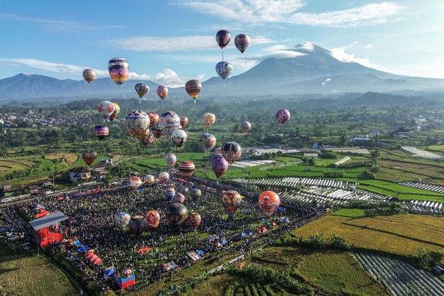 An aerial image shows hot air balloons, mostly made from recycled paper and tied with ropes, floating in the air during the annual hot air balloon festival, held since 1950 to celebrate Eid al-Fitr, the Islamic holiday marking the end of Ramadan, in Wonosobo, Central Java, on April 2, 2025. (Photo by Devi Rahman/AFP Photo)