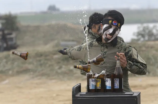 A South Korean army special forces soldier breaks bottles with his hand during the Naktong River Battle re-enactment in Waegwan, South Korea, Thursday, September 22, 2016. South Korean Defense Ministry reenacted one of the important battles as part of commemoration events for the 66th anniversary of the Korean War. (Photo by Ahn Young-joon/AP Photo)