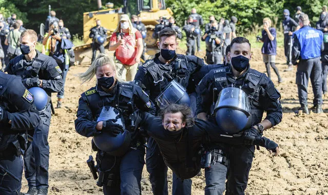 Police forces carry away an activist who had occupied a caterpillar vehicle in Hessen, Germany on September 21, 2020. An area is currently being prepared on which, according to police, the construction equipment for the construction of the A49 is to be parked. Activists are resisting the continued construction of the Autobahn 49 in the Dannenröder Forest. (Photo by Andreas Arnold/dpa)