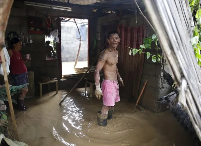 Residents stand in muddy floodwaters inside their house in Cabanatuan city, Nueva Ecija in northern Philippines October 20, 2015, after the province was hit by Typhoon Koppu. (Photo by Erik De Castro/Reuters)