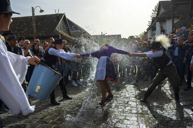 Hungarian men wearing folk costumes pour water onto women during a traditional a Easter Monday celebration in Holloko, Hungary, Monday, April 1, 2024. This Easter ritual is mostly confined to Central Europe. (Photo by Denes Erdos/AP Photo)
