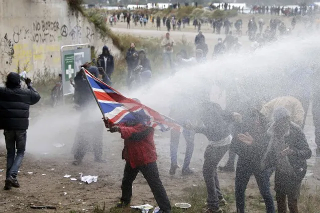 French police use water canon to disperse demonstrators who hold a march near the “jungle” where migrants live in Calais, France, October 1, 2016. (Photo by Pascal Rossignol/Reuters)