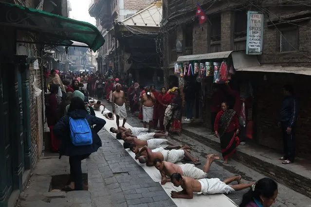 Hindu devotee offer prayers by rolling on the ground as a part of a ritual during the “Madhav Narayan” festival in Bhaktapur, on the outskirts of Kathmandu on January 26, 2023. (Photo by Prakash Mathema/AFP Photo)