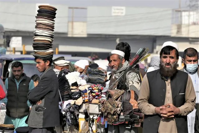 Street vendors wait for customers along a road in old area of Peshawar, Pakistan, Wednesday, February 1, 2023. (Phoot by Muhammad Sajjad/AP Photo)