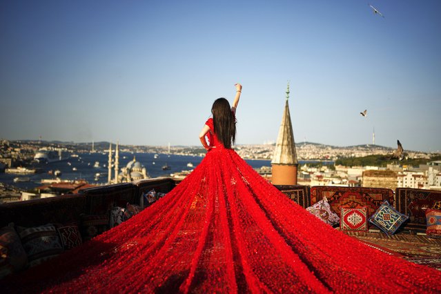 A tourist takes photos in an open-air studio with a view of the Bosphorus in Istanbul, Turkey, Saturday, July 19, 2025. (Photo by Emrah Gurel/AP Photo)