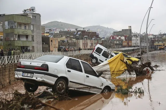 Cars and debris are scattered during floods after heavy rains in Sanliurfa, Turkey, Wednesday, March 15, 2023. (Photo by Hakan Akgun/DIA via AP Photo)