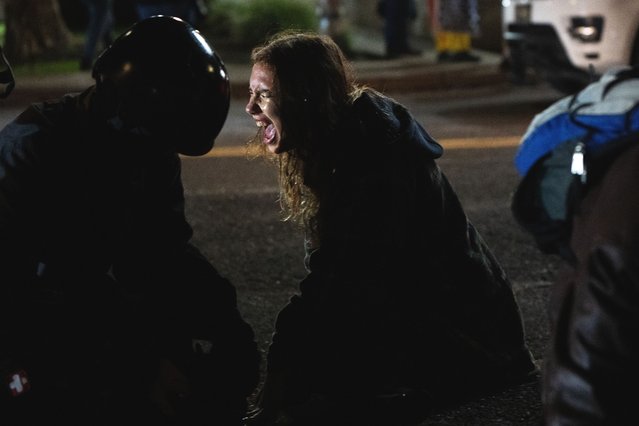 A protester reacts after getting sprayed by a Department of Homeland Security officer outside a U.S. Immigration and Customs Enforcement facility on Thursday, October 2, 2025, in Portland, Ore. (Photo by Jenny Kane/AP Photo)