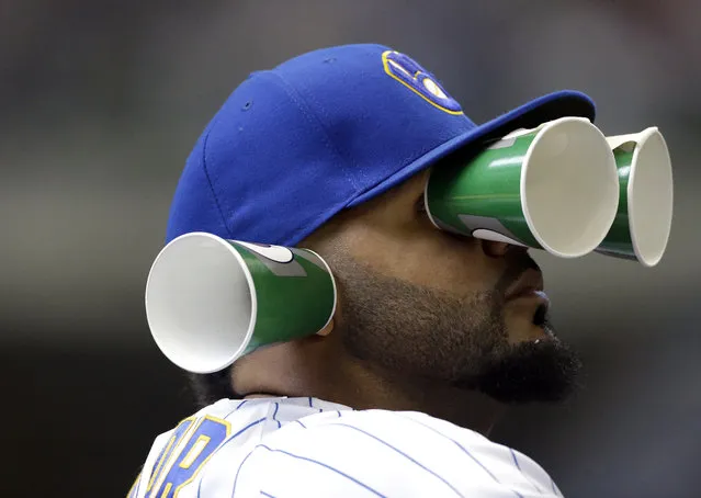 Milwaukee Brewers' Jonathan Villar watches from the dugout with cups on his face during the fifth inning of a baseball game against the Miami Marlins Sunday, April 22, 2018, in Milwaukee. (Photo by Aaron Gash/AP Photo)