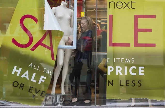 A shop assistant creates a window display in a Next store in central London December 30, 2014.  British clothing retailer Next's sales rose 2.9 percent in the run up to Christmas mostly due to online and catalogue purchases, hitting the upper end of its predictions and it said full-year profit would rise by about 11.5 percent. (Photo by Neil Hall/Reuters)