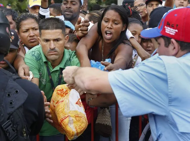 People crowd together in an attempt to buy chickens at a Mega-Mercal, a subsidized state-run street market, in Caracas January 24, 2015. President Nicolas Maduro shook up complex currency controls on Wednesday and also prepared Venezuelans for a rise in the world's cheapest fuel prices in response to a recession worsened by plunging oil revenue. (Photo by Carlos Garcia Rawlins/Reuters)