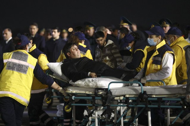 Wounded passengers of the Azerbaijani Airline's plane crashed near the Kazakhstani city of Aktau, are transported from a medical plane at the Heydar Aliyev International Airport outside Baku, Azerbaijan, Thursday, December 26, 2024. (Photo by AP Photo/Stringer)