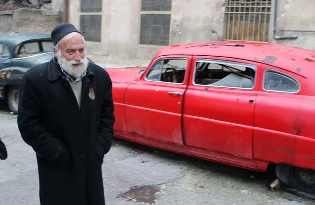 Mohamed Badr al-Din stands in front of one of his cars along a street where he keeps them, in the al-Shaar neighborhood of Aleppo January 31, 2015. (Photo by Abdalrhman Ismail/Reuters)