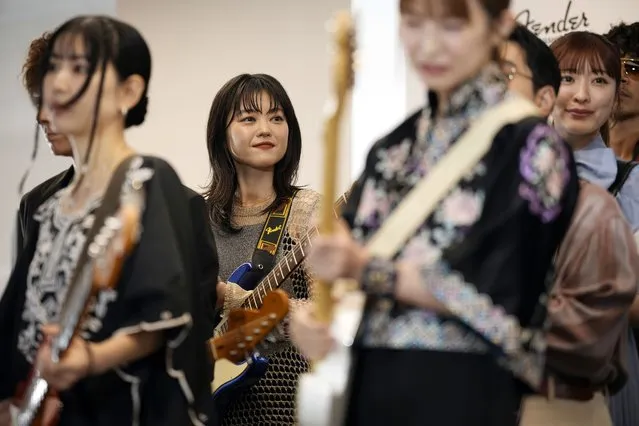 Erino Yumiki, center, a Japanese guitarist and songwriter, attends the opening ceremony of Fender's Tokyo store Thursday, June 29, 2023. (Photo by Eugene Hoshiko/AP Photo)