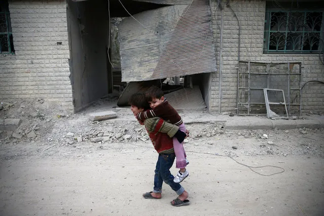 Children play near a damaged building in the rebel-held besieged city of Douma, in the eastern Damascus suburb of Ghouta, Syria November 13, 2016. (Photo by Bassam Khabieh/Reuters)