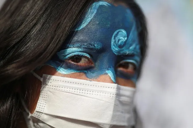 A woman with a painted face attends a protest during a rally called “Argentina in a Climate Emergency” in Buenos Aires, Argentina on March 22, 2021. (Photo by Agustin Marcarian/Reuters)
