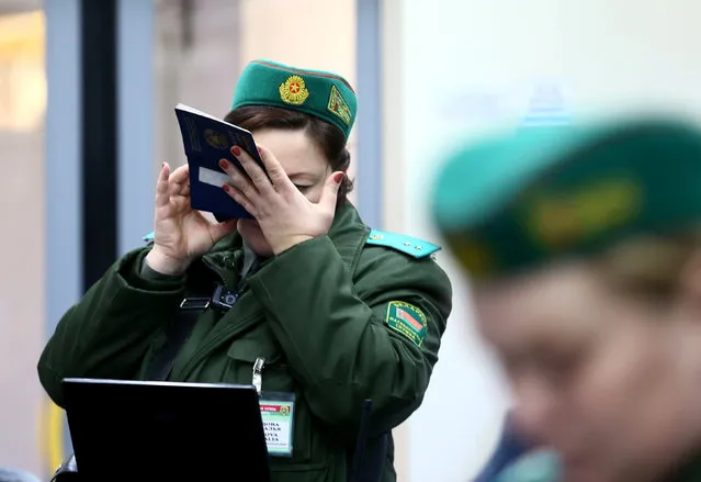 A Belarussian border guard checks a passenger's passport with magnifying glass in a train after it arrived from Lithuania, at the railway station Gudogai, Belarus, November 22, 2016. (Photo by Vasily Fedosenko/Reuters)