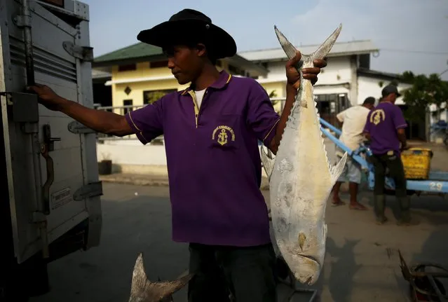 A worker carries a frozen fish to sell at Muara Angke fish auction in Jakarta, January 4, 2016. (Photo by Reuters/Beawiharta)