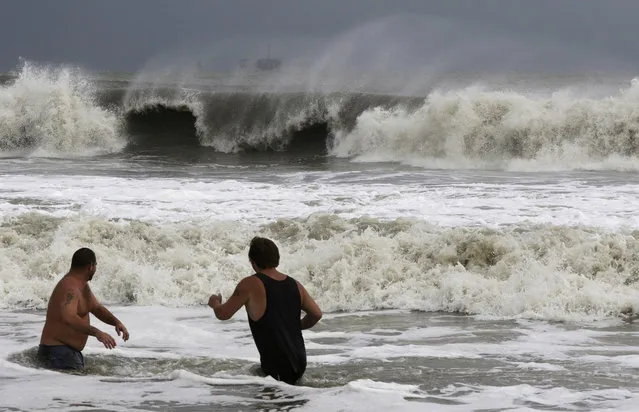 John Cunningham, left, and Hunter Shows, right, watch the waves crash from Tropical Storm Gordon on Tuesday, September 4, 2018, in Dauphin Island, Ala. (Photo by Dan Anderson/AP Photo)
