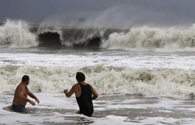 John Cunningham, left, and Hunter Shows, right,  watch the waves crash from Tropical Storm Gordon on Tuesday, September 4, 2018, in Dauphin Island, Ala. (Photo by Dan Anderson/AP Photo)