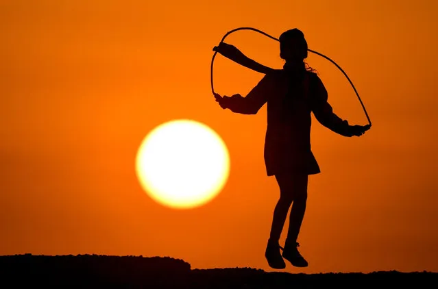 A child skips on a jumping rope during sunrise in Kuwait City, Kuwait, 14 November 2016. (Photo by Raed Qutena/EPA)