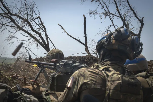Ukrainian soldiers fire toward Russian positions from a trench on the frontline in Zaporizhzhia region, Ukraine, Friday, June 23, 2023. (Photo by Efrem Lukatsky/AP Photo)