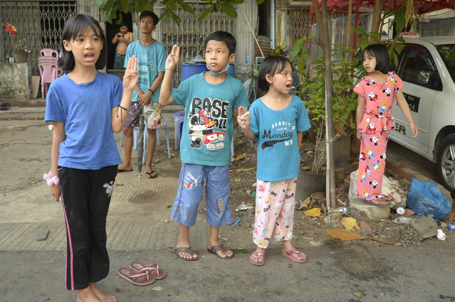Children flash the three-fingered symbol of resistance as they join an anti-coup protest in Yangon, Myanmar, Saturday, April 10, 2021. Security forces in Myanmar cracked down heavily again on anti-coup protesters Friday even as the military downplayed reports of state violence. (Photo by AP Photo/Stringer)