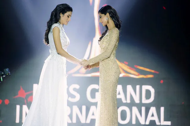 In this October 25, 2018, photo released by Miss Grand International Co., Ltd., finalists, Clara Sosa of Paraguay, left, hold hands with Meenakshi Chaudhary of India before the winner was announced during Miss Grand International 2018 in Yangon, Myanmar. Miss Grand International 2018 Sosa fell while the first runner-up Miss India Chaudhary tried to help. Sosa soon recovered and had a teary smile as she was crowned. (Photo by Miss Grand International Co., Ltd. via AP Photo)