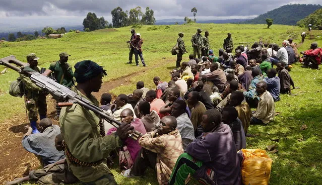 Congolese soldiers guard suspected M23 rebel fighters who surrendered in Chanzo village in the Rutshuru territory near the eastern town of Goma, November 5, 2013. Democratic Republic of Congo's M23 rebel group on Tuesday called an end to a 20-month revolt after the army captured its last hilltop strongholds, raising hopes for peace in a region where millions have died in nearly two decades of violence. (Photo by Kenny Katombe/Reuters)