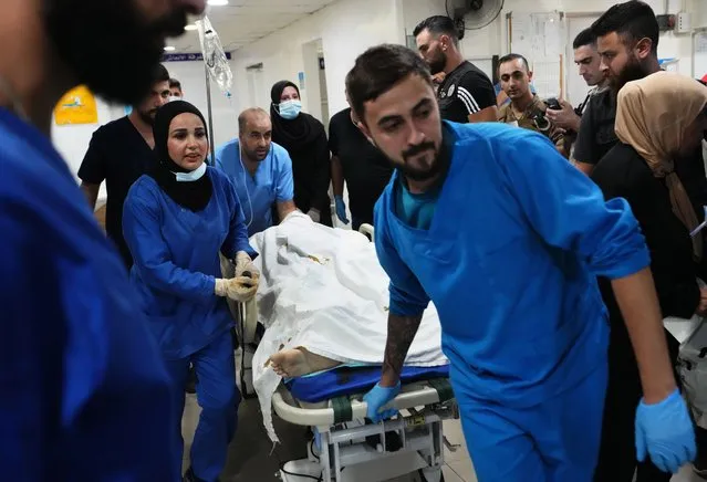 Nurses wheel in a journalist injured by Israeli shelling in Alma al-Shaab border village with Israel, at a hospital in the southern port city of Tyre, Lebanon, Friday, October 13, 2023. (Photo by Hassan Ammar/AP Photo)