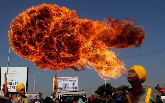 An Indian Sikh devotee spits fire as he performs during religious procession ahead of the birth anniversary of the first Sikh Guru or master, Sri Guru Nanak Dev Ji, the founder of Sikhism, in Jammu, the winter capital of Kashmir, India, 21 November 2018. The birth anniversary of Guru Nanak Dev Ji will be observed on 23 November 2018. (Photo by Jaipal Singh/EPA/EFE)