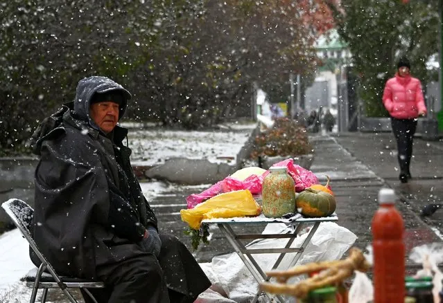 A street vendor sells vegetables during snowfall in Omsk, Russia on October 24, 2023. (Photo by Alexey Malgavko/Reuters)