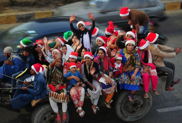 Pakistani revellers, some dressed in “Santa Claus” hats, take part in a camel rally in Karachi on December 21, 2016, ahead of the celebration of Christmas. (Photo by Asif Hassan/AFP Photo)
