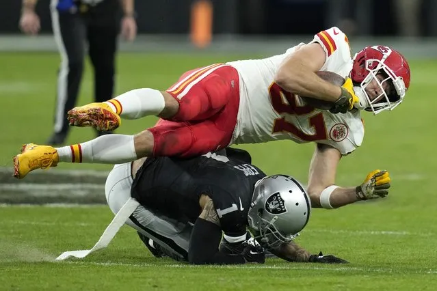 Kansas City Chiefs tight end Travis Kelce, top, is tackled by Las Vegas Raiders safety Marcus Epps during the second half of an NFL football game, Sunday, November 26, 2023, in Las Vegas. (Photo by John Locher/AP Photo)