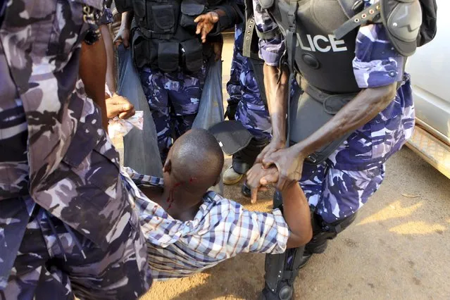 Riot police detain a supporter of Uganda's leading opposition party Forum for Democratic Change as police and military forces disperse their procession with their presidential candidate to a campaign ground in Kampala, Uganda, February 15, 2016. (Photo by James Akena/Reuters)
