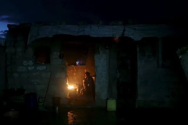 Members of a Palestinian family sit around a fire as they warm themselves inside their dwelling on a rainy day in Khan Younis in the southern Gaza Strip February 7, 2016. (Photo by Ibraheem Abu Mustafa/Reuters)