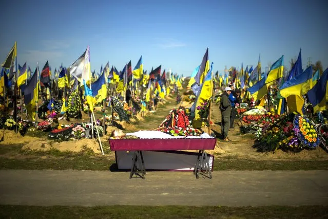 The body of recently killed Ukrainian serviceman Vadim Bereghnuy, 22, rests in a coffin during his funeral in a cemetery in Kharkiv, Ukraine, Monday, October 17, 2022. (Photo by Francisco Seco/AP Photo)