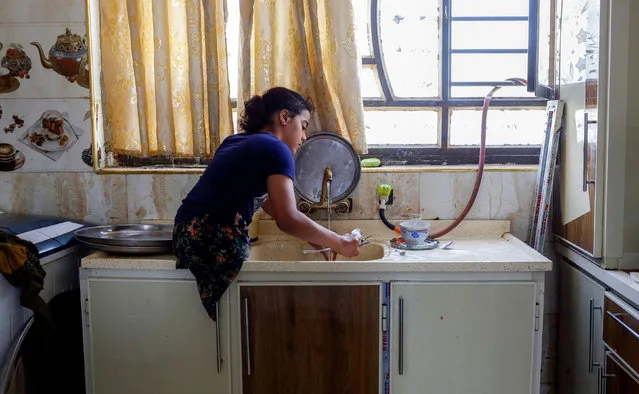 Fatima Fawzi, a jiu-jitsu practitioner, washes spoons at home in Baghdad, Iraq on June 16, 2021. (Photo by Saba Kareem/Reuters)