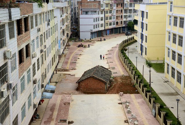 A “nail house”, the last building in the area, sits in the middle of a road under construction in Nanning, Guangxi Zhuang Autonomous Region April 10, 2015. According to local media, the owner of the house didn't reach an agreement with the local authority about compensation of the demolition. (Photo by Reuters/Stringer)