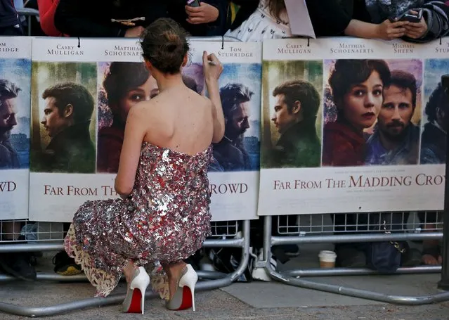 Actress Carey Mulligan signs a poster at the world premiere of “Far From the Madding Crowd” at the BFI Southbank in London, April 15, 2015. (Photo by Cathal McNaughton/Reuters)