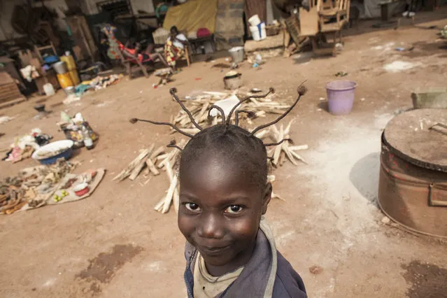 A young girl passes an informal market in M'Poko Internally Displaced Persons camp in Bangui, Central African Republic on Saturday, February 13, 2016. (Photo by Jane Hahn/The Washington Post)