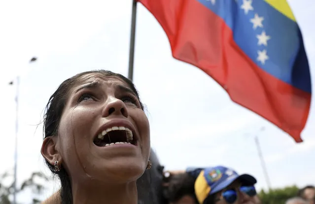 Venezuelan migrant Yanela Aleman cries as she sings her national anthem in La Parada, near Cucuta, Colombia, on the border with Venezuela, Sunday, February 17, 2019. As part of U.S. humanitarian aid to Venezuela, Sen. Marco Rubio, R-Fla is visiting the area where the medical supplies, medicine and food aid is stored before it it expected to be taken across the border on Feb. 23. (Photo by Fernando Vergara/AP Photo)