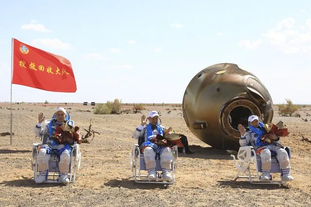 In this photo released by Xinhua News Agency, Chinese astronauts from left, Tang Hongbo, Nie Haisheng and Liu Boming wave at the Dongfeng landing site in northern China's Inner Mongolia Autonomous Region on Friday, September 17, 2021. The trio of Chinese astronauts returned to Earth on Friday after a 90-day stay aboard their nation's first space station in China's longest mission yet.(Photo by Ju Zhenhua/Xinhua via AP Photo) 